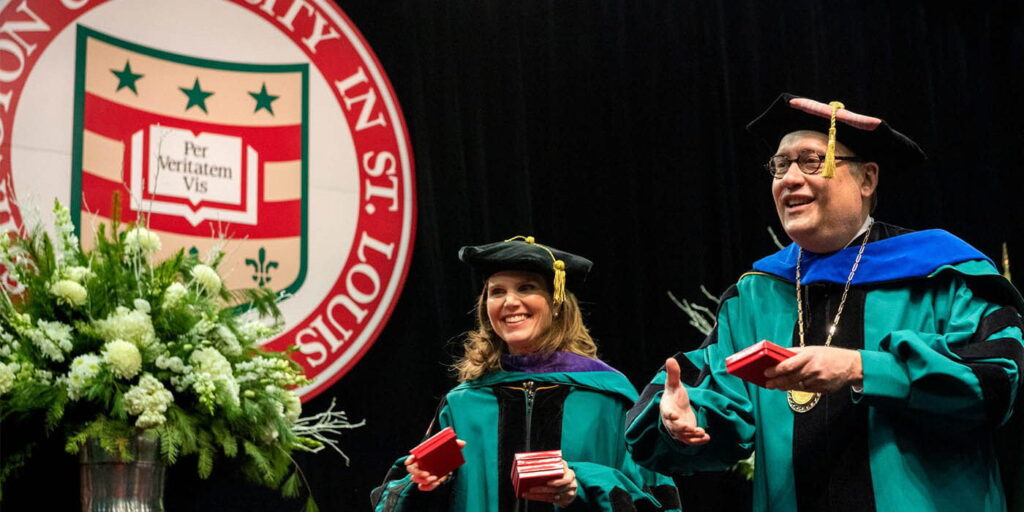 Rebecca Brown, vice chancellor, secretary to the Board of Trustees and chief of staff, and Chancellor Andrew D. Martin congratulate graduates at the 2019 December recognition ceremony